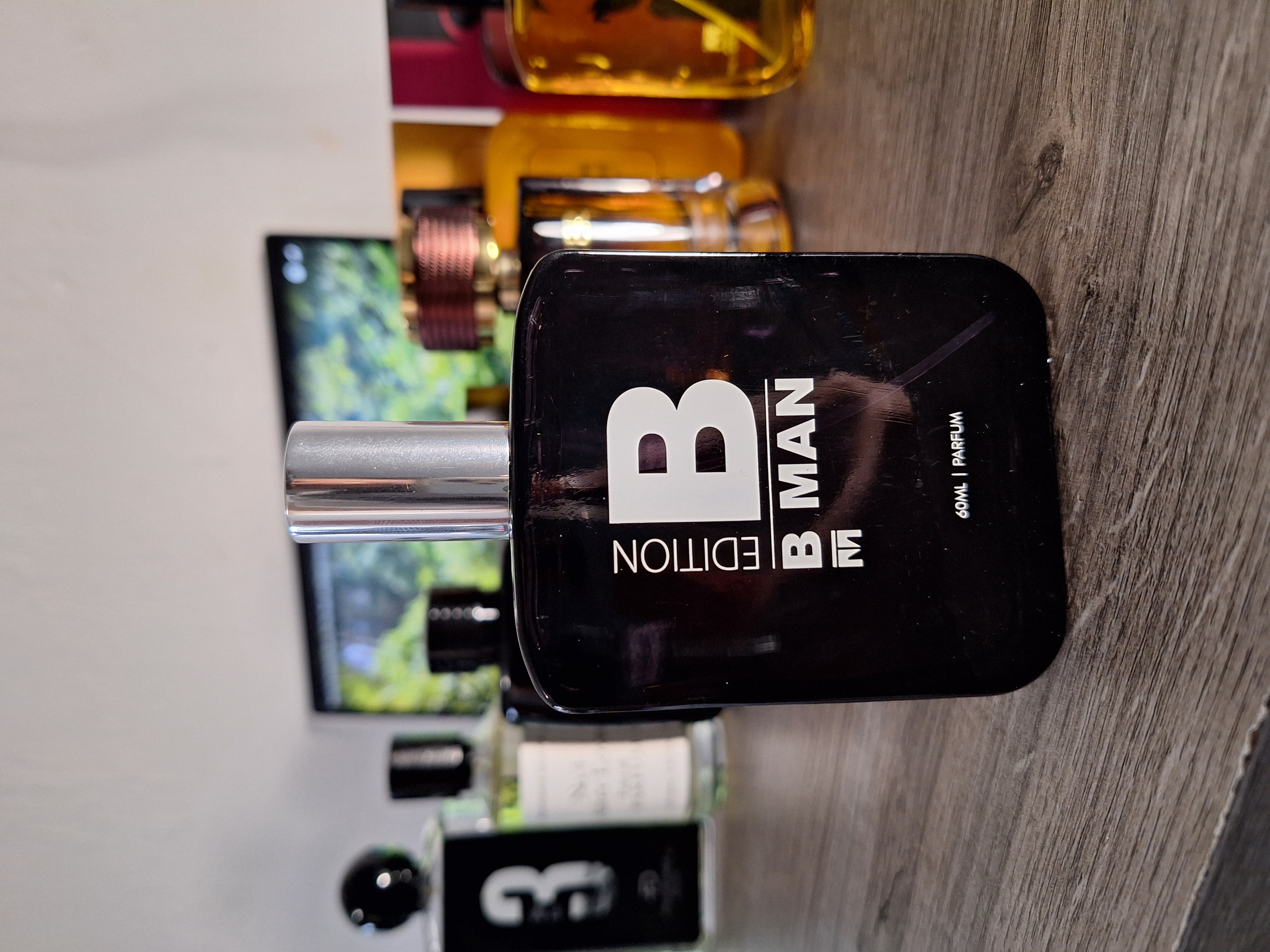 B Man perfume bottle with masculine geometric design and dark liquid
